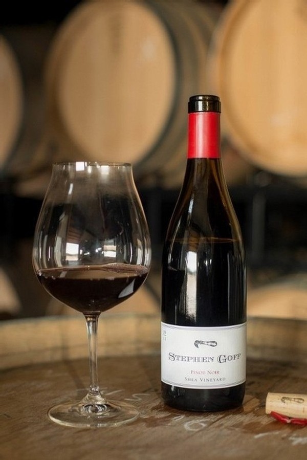 Wine Glass and bottle of Stephen Goff Wine in the barrel room